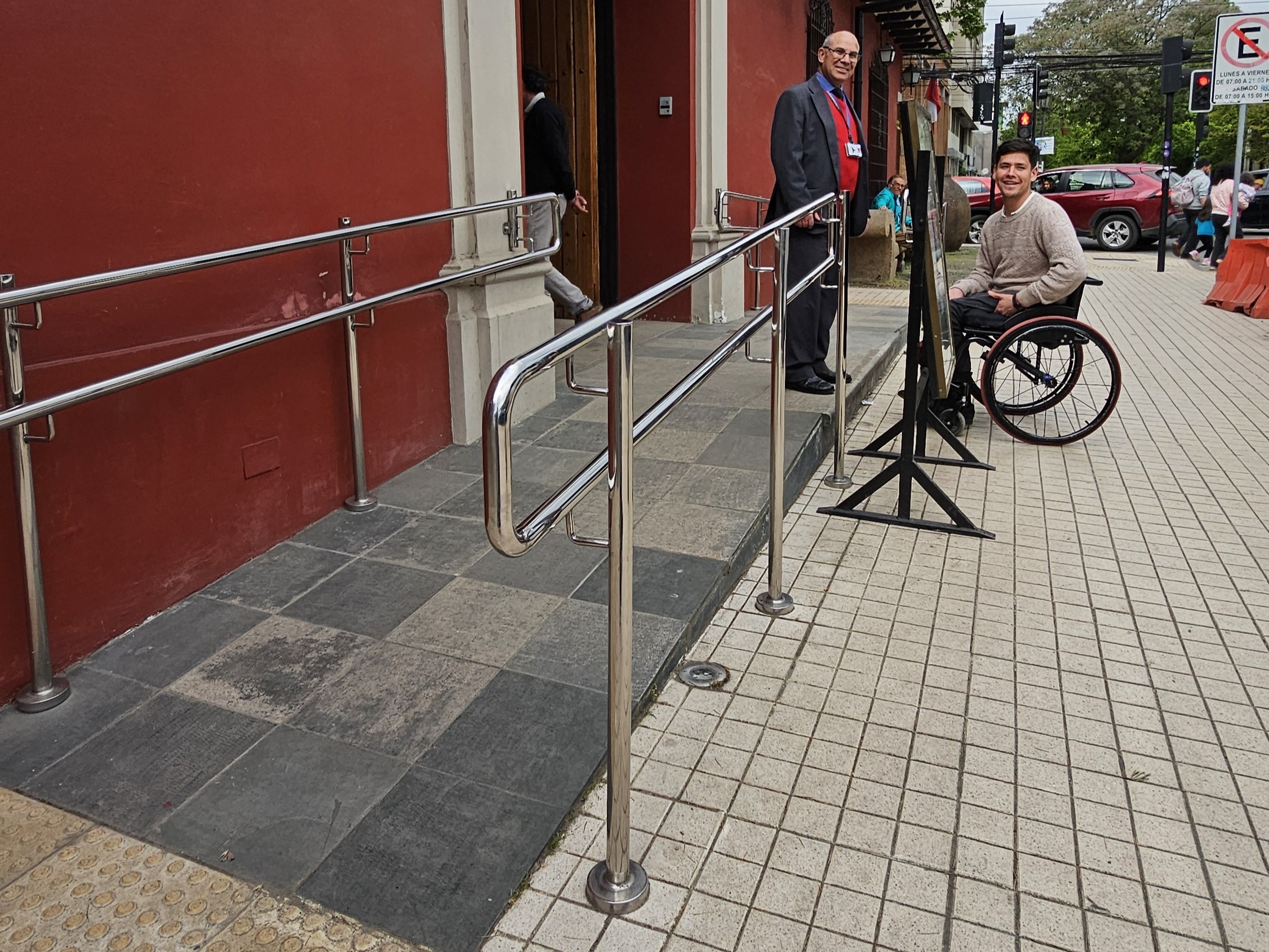 Fotografía de la Entrada accesible del museo, se aprecia una rampa, una persona en silla de ruedas y un trabajador del museo